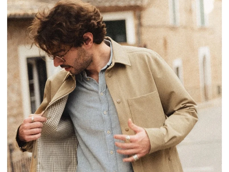 Man draagt een beige MOS MOSH Gallery overshirt met lichtblauw overhemd en lichte broek